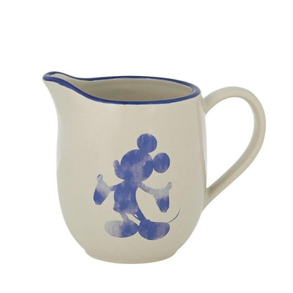 The Disney Home Mono Cream Jug (A30830) is cream-colored with a blue rim and handle, featuring a blue watercolor-style Mickey Mouse silhouette on the side.
