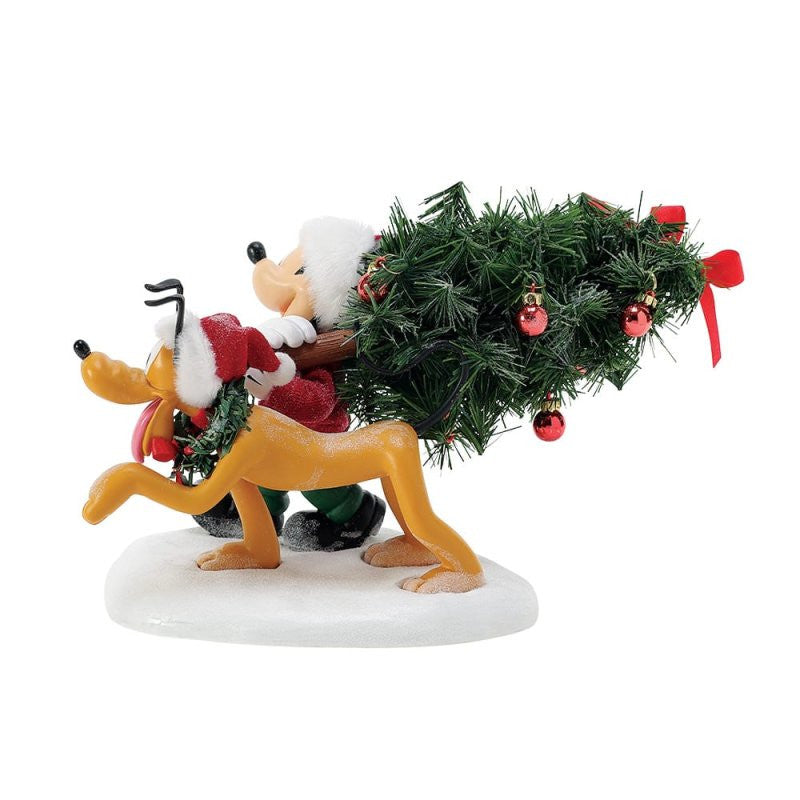 The Department 56 Disney Mickey’s Perfect Tree Possible Dreams figurine features Mickey dressed as Santa riding behind Pluto, who pulls a decorated tree, all set on a snowy base.