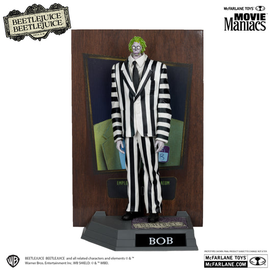 The McFarlane Toys Movie Maniacs Shrinker Bob Platinum Version figurine stands on a BOB-labeled base, dressed in a striped black and white suit with a green tie, with retro Beetlejuice afterlife art and brand logos on the background.