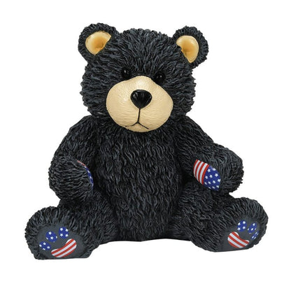 The Bubba Bearsevelt Figurine by Boyds Bears (6016928) features a black bear with a beige snout, yellow inner ears, and upright pose. Its paws display American flag stars and stripes, celebrating the brands 45th anniversary collection.