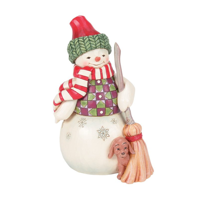 The Heartwood Creek By Jim Shore Swept In Love figurine (6017014) features a snowman with a red hat, green scarf, patterned vest, broom, and snowflake accents with a small brown dog peeking at the base.