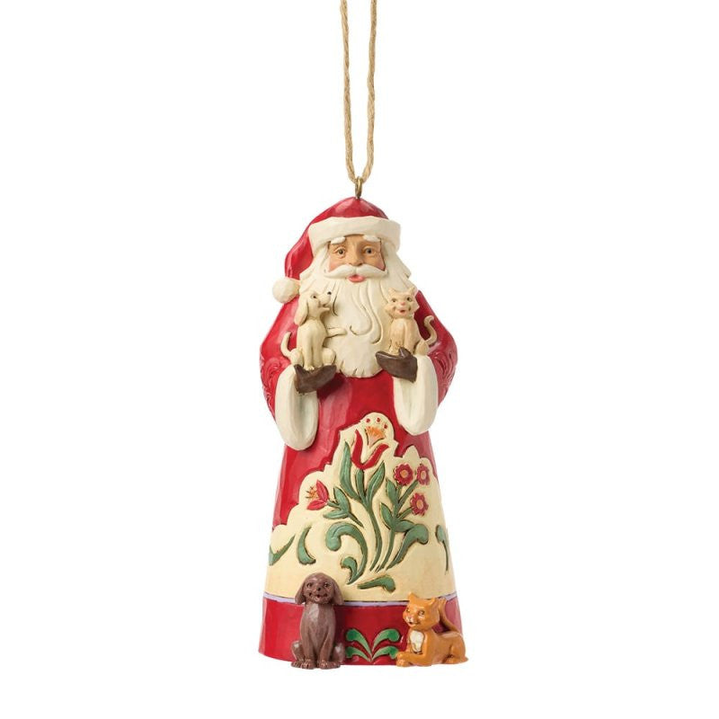 The Heartwood Creek By Jim Shore Santa With Pets Hanging Ornament (6017034) features Santa in a red coat with floral designs, holding a tan cat and dog, with a brown dog and orange cat at his feet. It hangs by a string.