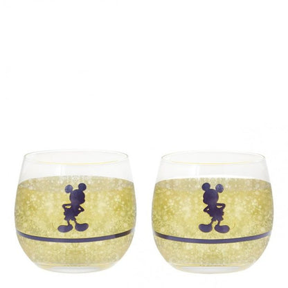 This set of 2 Disney Home Mono Mickey & Minnie Tumblers (A30845) features clear glass with a gold sparkling band and bold Mickey silhouettes, displayed empty and placed side by side.