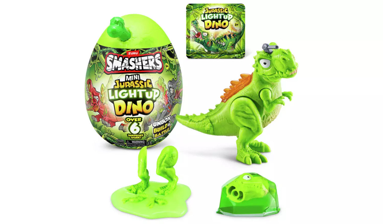 A Zuru Smashers Mini Jurassic Light-Up Dinosaur set featuring a glowing dinosaur figure, green Jurassic Light-Up Egg container, slime with dino bones, and the packaging in the background.