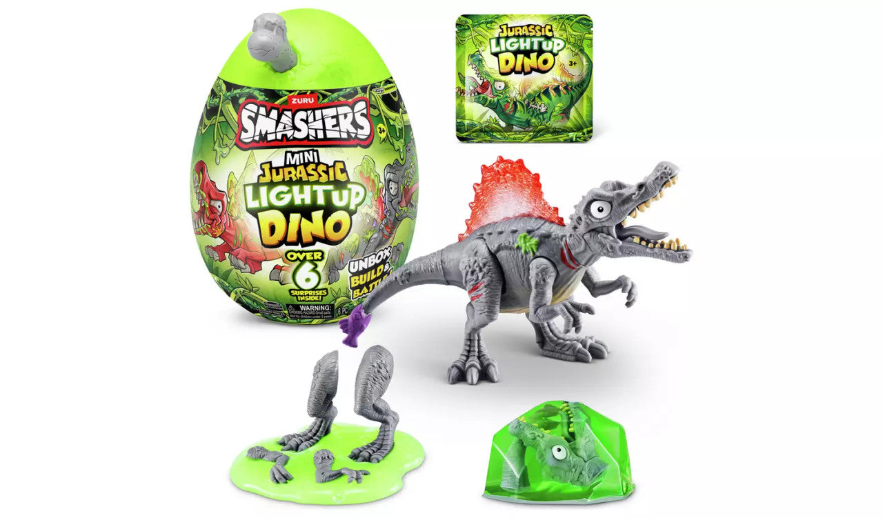 The Zuru Smashers Mini Jurassic Light-Up Dinosaur set by Zuru includes a green egg, Smash-o-saur parts with a red light-up back, green slime, and packaging with colorful dinosaur graphics.