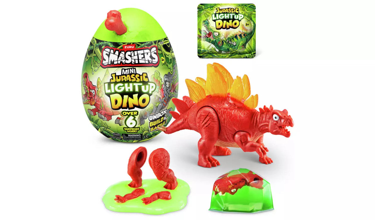 The Zuru Smashers Mini Jurassic Light-Up Dinosaur toy set includes a green egg, small packet, red dinosaur parts, green slime, and a fully assembled red dinosaur with yellow plates on its back.