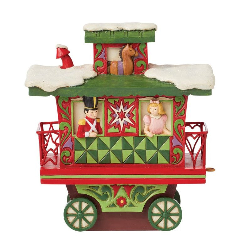 The Heartwood Creek By Jim Shore North Pole Delivery (Train Car Caboose) Figurine 6015481 features snow on the roof, toy soldier and doll in the windows, a rocking horse on top, and festive green and red patterns—an ideal display piece.