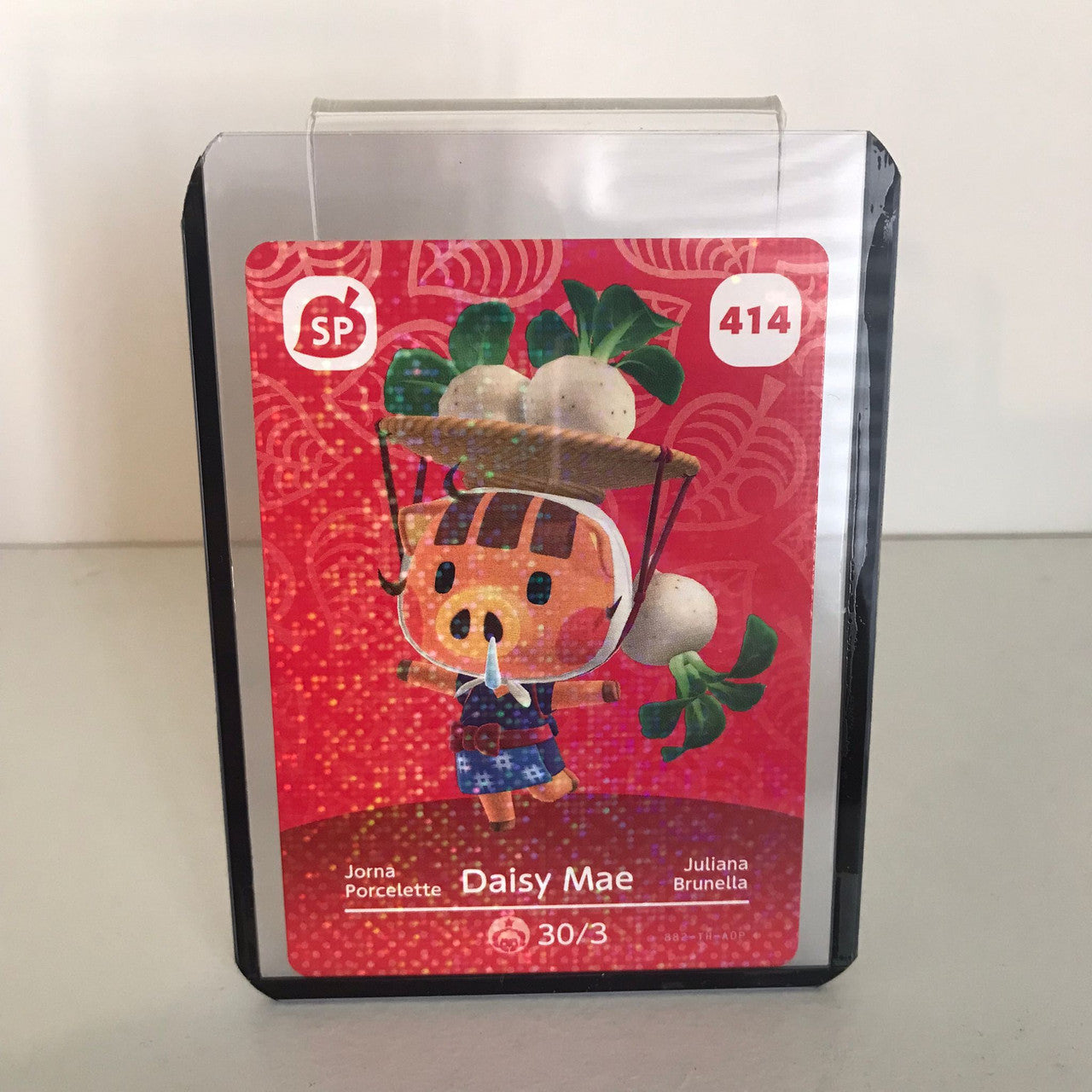 The Nintendo Amiibo Animal Crossing Card Series 5 features Daisy Mae (No. 414) with turnips on her head, set against a red pattern. The collectible card comes in a protective plastic holder.