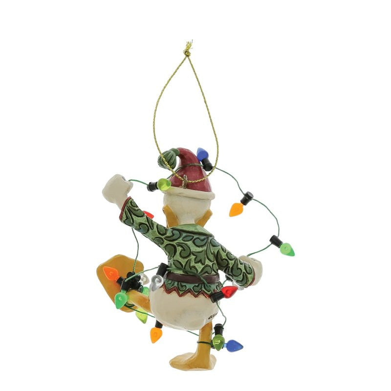 The Disney Traditions Donald Duck Wrapped In Lights Hanging Ornament by Jim Shore (6017548) features Donald in a green sweater and red hat tangled in lights, hanging by a gold string—a fun addition to your Disney Traditions collection.