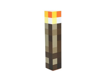 The Minecraft Torch Light By Paladone features a pixelated, rectangular design with a brown base, lighter brown middle, and yellow-orange flame top; it can be displayed on a table or mounted on the wall for versatile use.