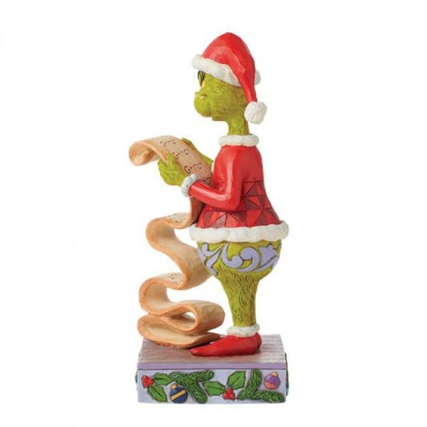 The Grinch By Jim Shore 6015217 figurine features the Grinch in a red Santa suit on a decorative base, holding his Naughty/Nice List—perfect for adding Christmas cheer to your décor.