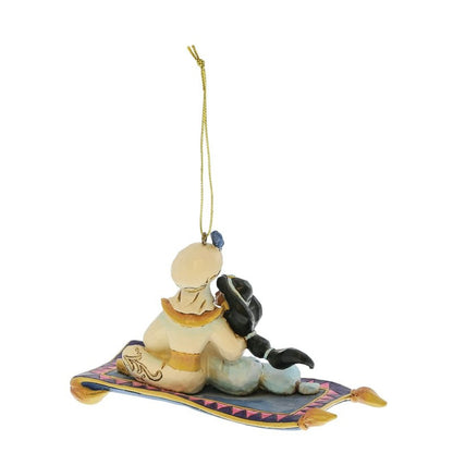 The Disney Traditions Aladdin & Jasmine Hanging Ornament by Jim Shore (6017550) features the duo in cream, yellow, and blue on a patterned flying carpet, viewed from behind and includes a gold string for hanging.