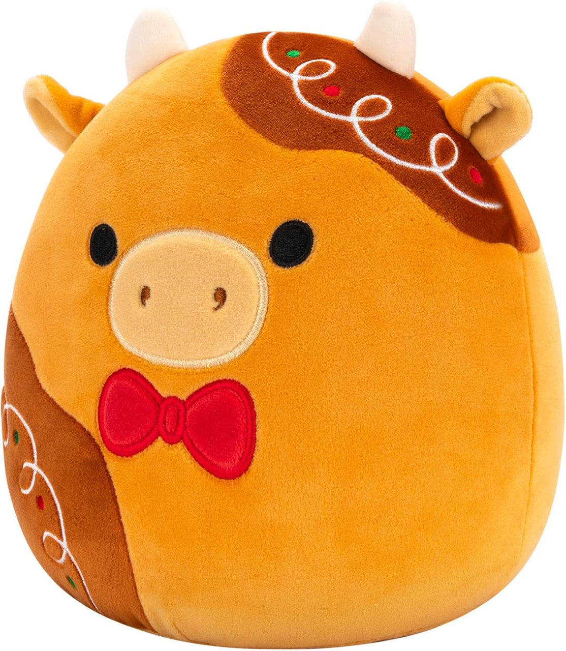 Squishmallows Jericho the Gingerbread Cow is a plush toy shaped like a cow with tan and brown patterns, small horns, embroidered eyes, a beige snout, red bow tie, and icing details—an adorable collectible from Squishmallows.