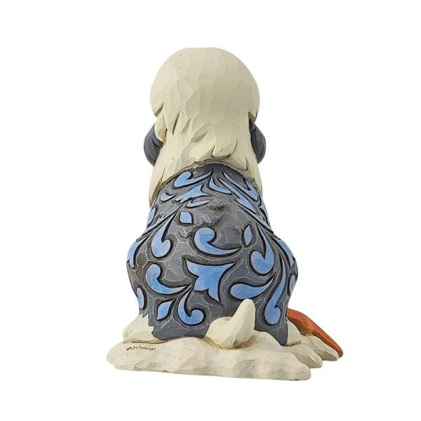 The Disney Traditions Max Mini Figurine 6014334 features a decorative dog viewed from behind, with blue and gray patterns on its back, a white tail, and sits on a textured base—a charming collectible inspired by The Little Mermaid.