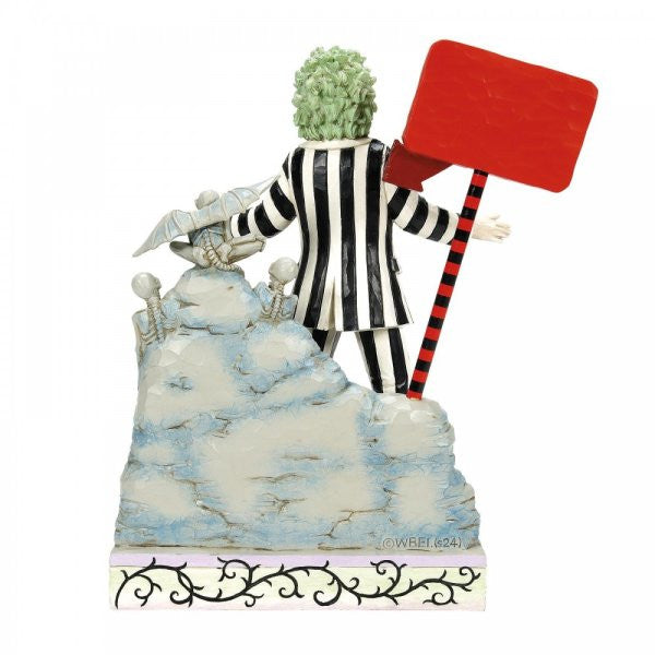 The Beetlejuice By Jim Shore LED Light-up Figurine 6016175 features the iconic green-haired character in a black-and-white striped suit, standing on a rocky base with a bold red sign and lit by LEDs.