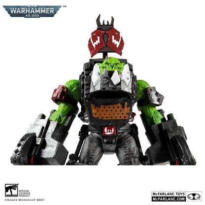 The image shows a Warhammer 40,000 Ork Meganob with Buzzsaw action figure by McFarlane Toys, featuring green skin, black and red armor with metal accents, and a red mask. Warhammer 40,000 and McFarlane Toys logos are also visible.