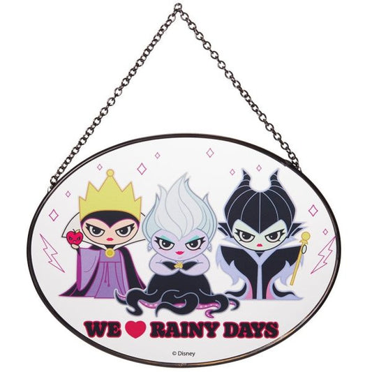 The Villains Suncatcher by Disney Garden 6014572 features cartoon Disney Villains—the Evil Queen, Ursula, and Maleficent—above the words “WE ♥ RAINY DAYS.” This Disney Garden suncatcher hangs by a small metal chain.
