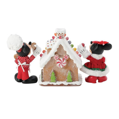 The Disney Mickey & Minnie’s Gingerbread House Possible Dreams Christmas Figurine by Department 56 (6016447) features the duo decorating a festive candy-adorned gingerbread house, bringing holiday magic to your decor.