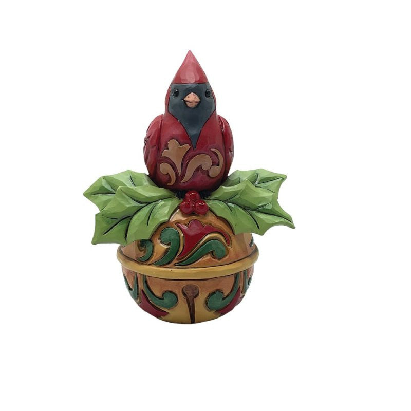 The Heartwood Creek By Jim Shore Cardinal On A Jingle Bell Mini Figurine (6017279) features a red cardinal perched on holly leaves and berries atop a decorative base—perfect for festive holiday décor.
