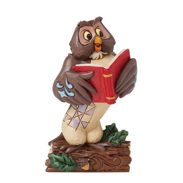 The Disney Traditions Owl Winnie the Pooh Mini Figurine by Jim Shore (6016350) features a decorative owl with large eyes, blue-patterned wings, standing on a log and reading an open red book, with green leaves at its base.