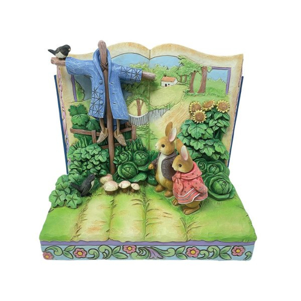 The Beatrix Potter Peter Rabbit Storybook Double Pack Figurines by Jim Shore features two clothed rabbits in a garden with cabbages, a scarecrow, birds, and a countryside storybook backdrop inspired by classic Peter Rabbit tales.