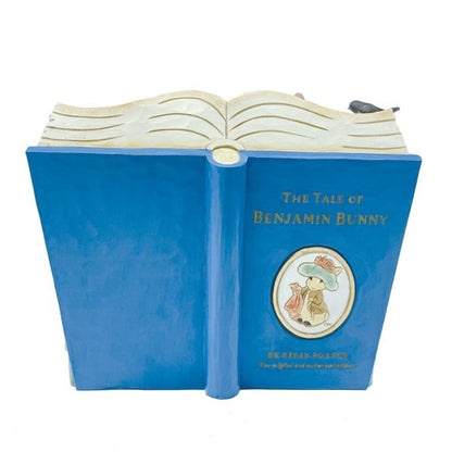 A decorative figurine from Beatrix Potter by Jim Shore, shaped like an open book featuring Peter Rabbit with a hat and the title The Tale of Benjamin Bunny, part of the Peter Rabbit Storybook Double Pack.