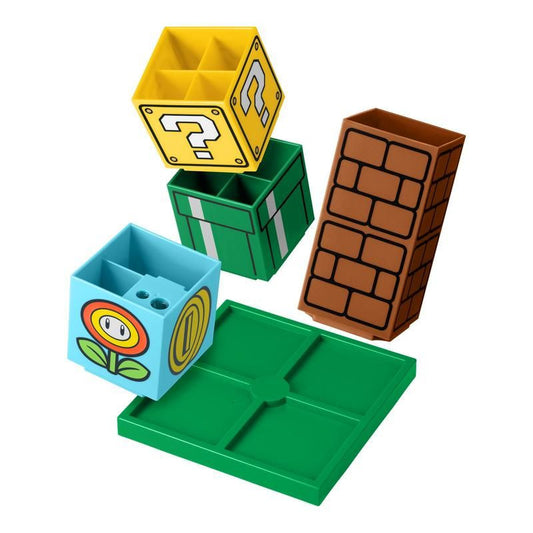 The Super Mario Desktop Organiser by Paladone features a yellow question block, green pipe, brown brick, and blue flower coin block on a green base—perfect for Nintendo fans.