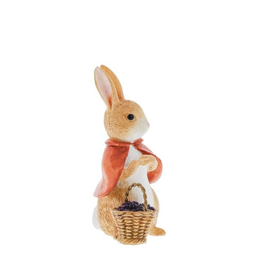 The Beatrix Potter Flopsy Bunny With Berries Figurine by Beatrix Potter features a brown and white bunny with a red cape, sitting upright and holding a basket of berries in its lap.