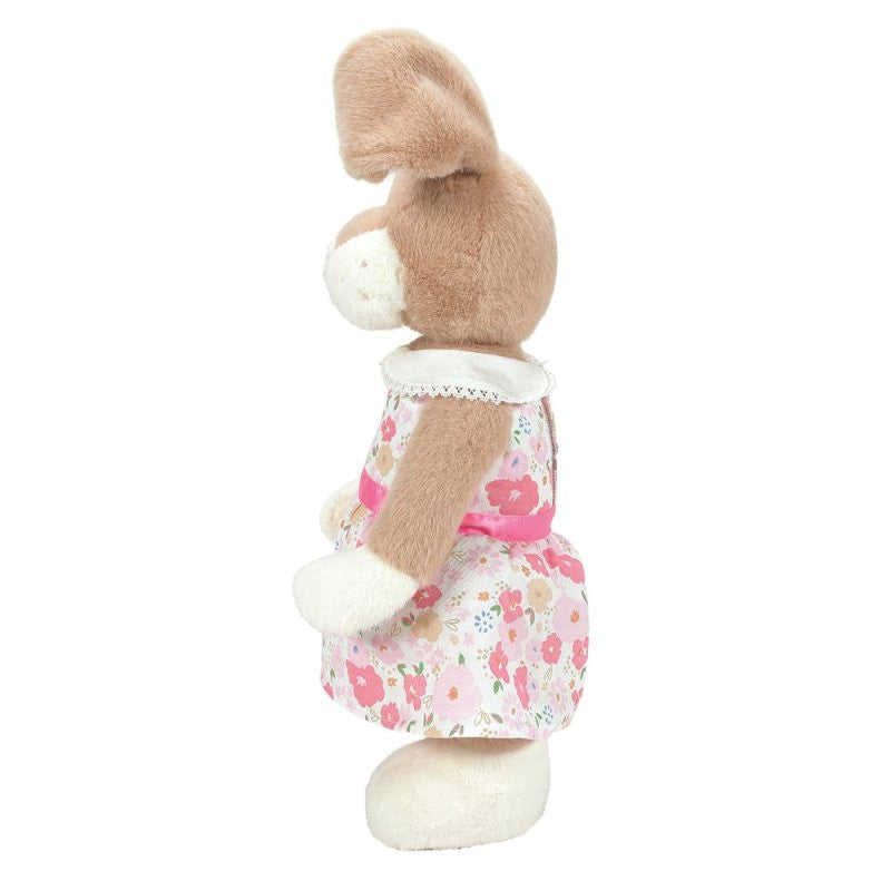 A side view of the Honey Hopplebuns 14 Inch Plush Soft Toy by Boyds Bears shows its brown and white fur, floral dress with a pink waistband and white collar, long ears, and cuddly appearance standing upright.
