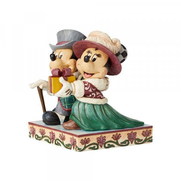 Disney Traditions Mickey and Minnie dressed in Victorian holiday outfits, Minnie holds a present Figurine