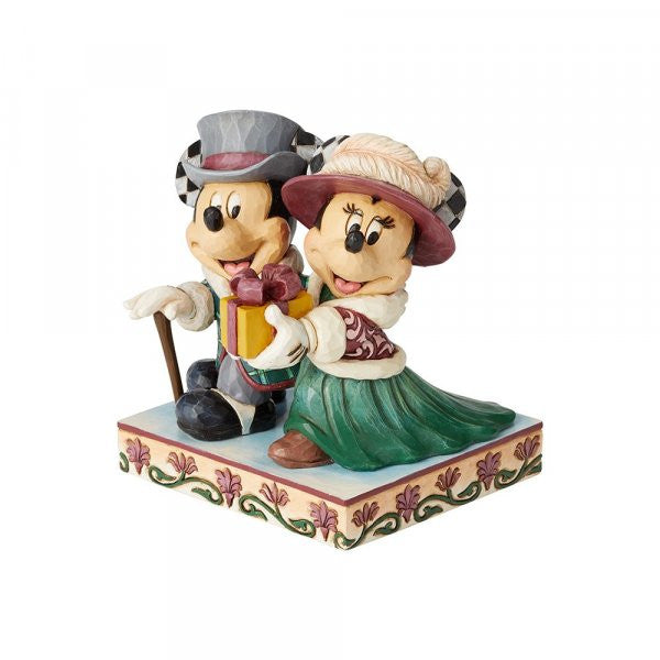 Disney Traditions Mickey and Minnie dressed in Victorian holiday outfits, Minnie holds a present Figurine