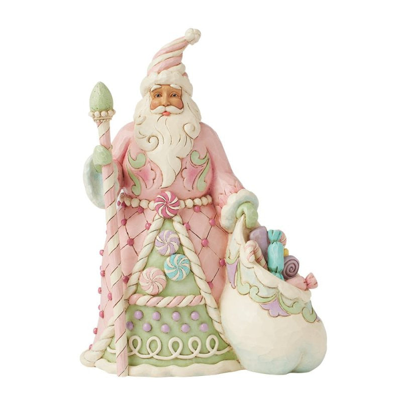 The Heartwood Creek By Jim Shore Sweet Treat Santa (Pastel Candy Santa) Figurine 6017018 features Santa in a pastel pink and green robe with candy designs, holding a staff and a sack of gifts from the charming Heartwood Creek collection.