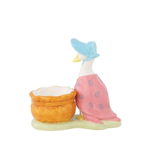 The Beatrix Potter Jemima Puddle-Duck Egg Cup features Jemima in a blue bonnet and pink shawl, standing beside an orange basket on a light green base.