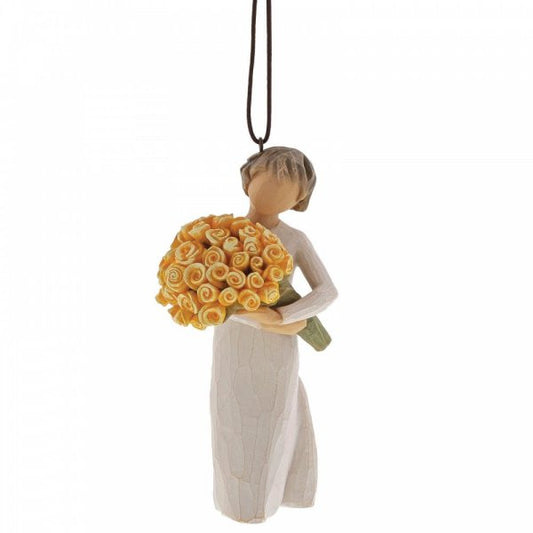The Willow Tree Good Cheer Hanging Ornament features a faceless figurine in a white dress with short light brown hair, holding yellow roses and suspended by a brown string—a thoughtful Willow Tree gift to celebrate friendship.