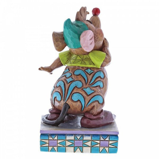 Disney Traditions Gus, the mouse friend of Cinderella,  eagerly anticipating a yummy snack, his round belly protruding beneath a snug green tee figurine