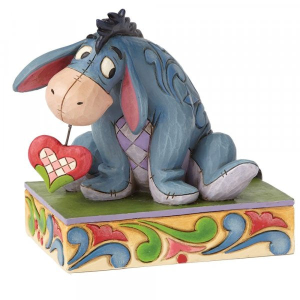 Disney Traditions Eeyore holds a folk-art inspired heart in his mouth figurine