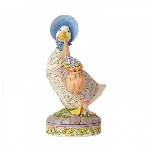 The Beatrix Potter by Jim Shore ..wearing a shawl and a poke bonnet Jemima Puddle-Duck Figurine features Jemima in a classic outfit, standing on a floral base—a charming gift for fans of Beatrix Potter.