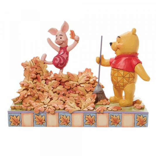 Disney Traditions Winnie the Pooh rakes a yard-full of leaves into a giant pile while Piglet prepares to leap into it figurine
