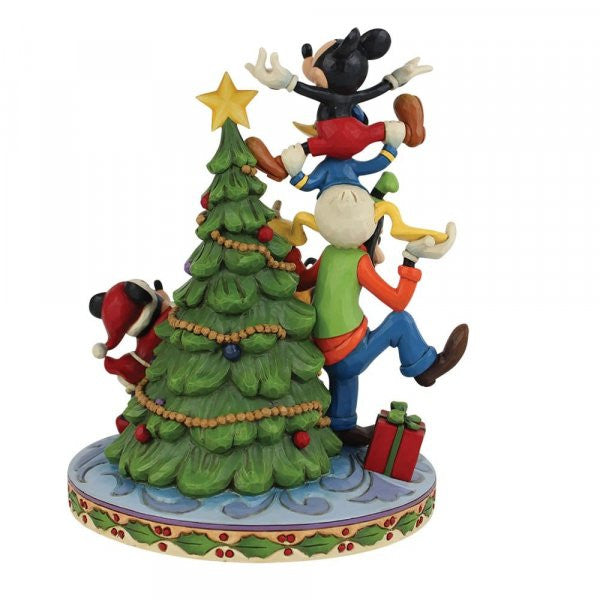 The Disney Traditions Merry Tree Trimming - Fab 5 Decorating Tree with Illuminated figurine features the beloved characters decorating a Christmas tree, with gifts at the base and festive details bringing holiday magic to your home.