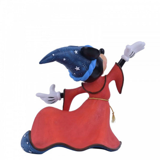 The Enesco Disney Showcase Sorcerer Mickey Figurine 6006274 features Mickey in a blue wizard hat with white stars and a red robe, striking a dramatic pose with one arm raised and the other extended forward.