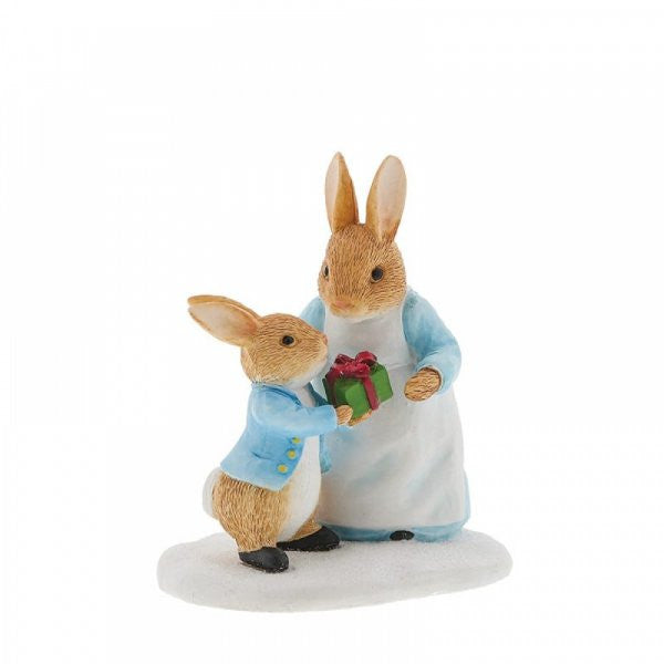 The Beatrix Potter Mrs. Rabbit Passing Peter Rabbit a Present Figurine features two rabbits, with Peter in blue giving a green gift box to Mrs. Rabbit—an adorable collectible and charming Christmas keepsake.