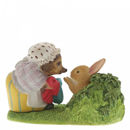 The Beatrix Potter Mrs. Tiggy-Winkle Returning Peters Laundered Jacket figurine depicts Mrs. Tiggy-Winkle with a red purse and suitcase facing a rabbit—an endearing collectable and perfect gift for adult fans.