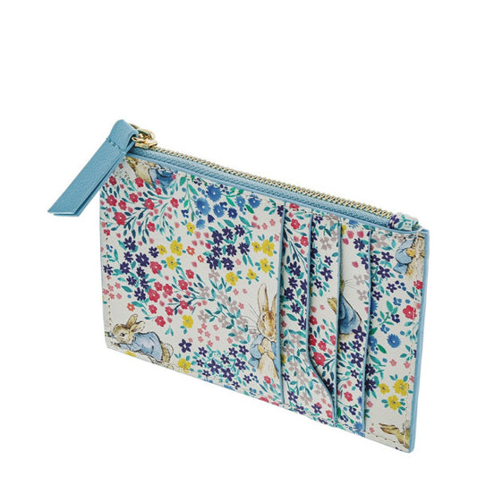 The Beatrix Potter Peter Rabbit Garden Party Pop Up Purse is a slim zippered cardholder pouch with blue trim, featuring multiple front card slots and decorated in a floral Garden Party pattern with Peter Rabbit illustrations.