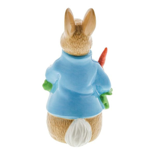The Beatrix Potter Peter Rabbit with Radishes Porcelain Figurine - Limited Edition shows Peter in a blue jacket, holding radishes behind his back—a delightful collectible for any Beatrix Potter enthusiast.