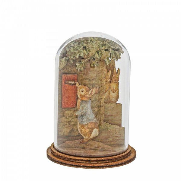 The Beatrix Potter Peter Posting Letter Wooden Figurine features two illustrated rabbits by a red mailbox, surrounded by greenery under an eco-friendly glass dome on a round wooden base, evoking vintage charm.