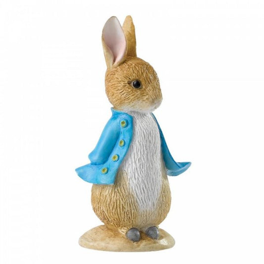 The Beatrix Potter Peter Rabbit Mini Figurine stands on a small base, wearing a blue jacket with yellow buttons. This brown rabbit has large ears, a white belly, and gray feet—charmingly inspired by Beatrix Potters classic character.