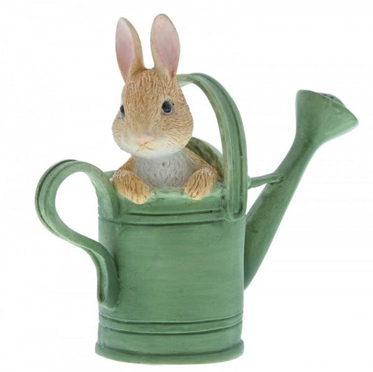 The Beatrix Potter Peter in Watering Can Mini Figurine features Peter sitting inside a green can with his head and paws over the rim, capturing the storybook charm of Beatrix Potter’s beloved tales.
