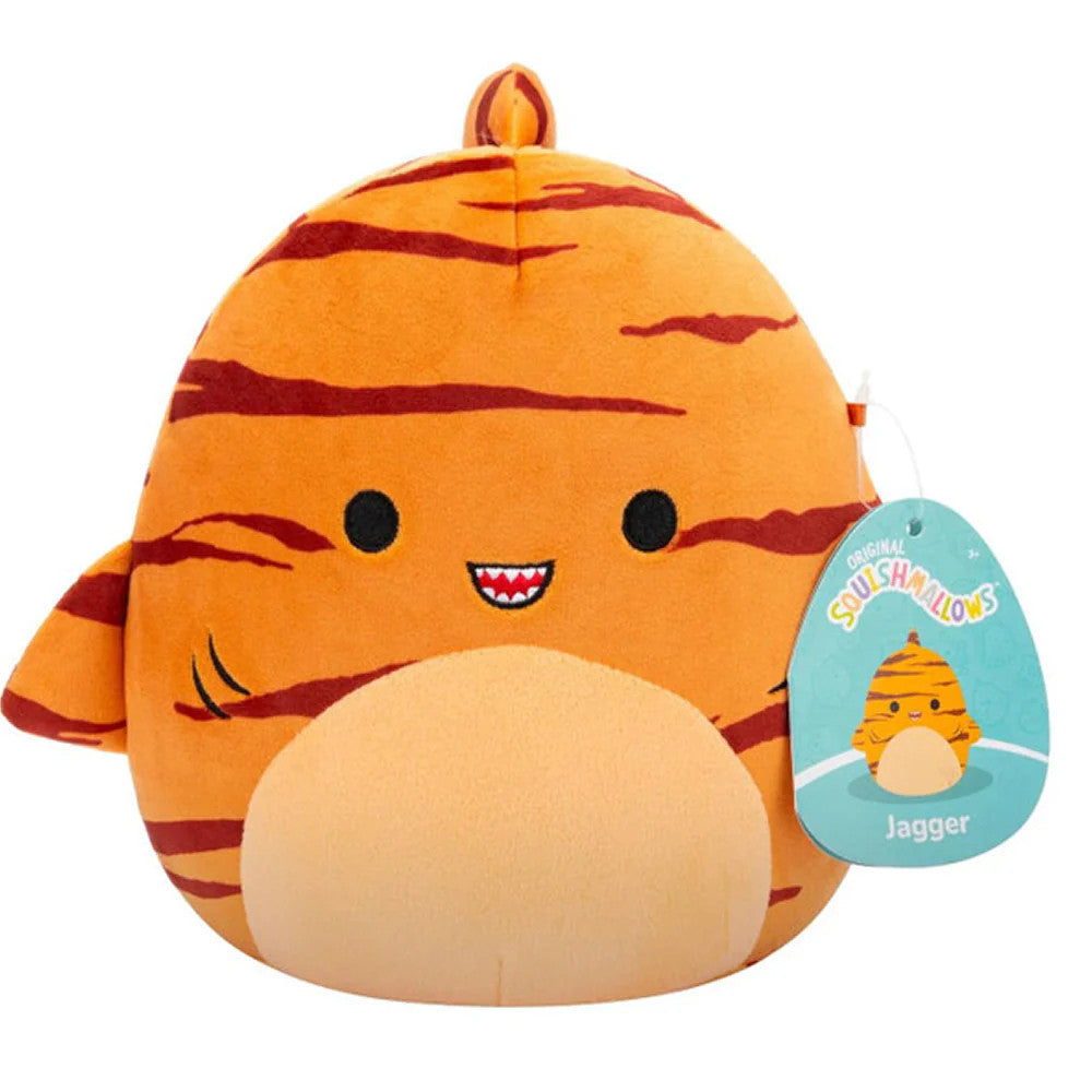 A 7.5 round orange plush from Squishmallows, Jagger the Tiger Shark features ultrasoft material, tiger-like stripes, small fins, a smiling face with tiny teeth, a beige belly, and comes with a tag showing his cartoon image.