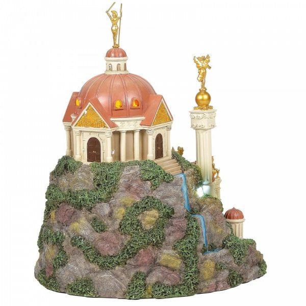 The Themyscira Building DC Village by Department 56 is a decorative model featuring a domed, classical-style building with columns, golden statues, small waterfalls, and mossy rocks; inspired by Themyscira.