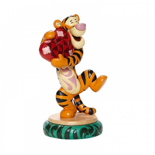 Disney traditions Tigger from Winnie the Pooh hugs a heart figurine